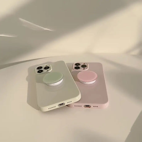 two iphones sitting on top of a white table