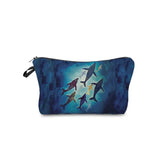 a blue cosmetic bag with three dolphins swimming in the ocean