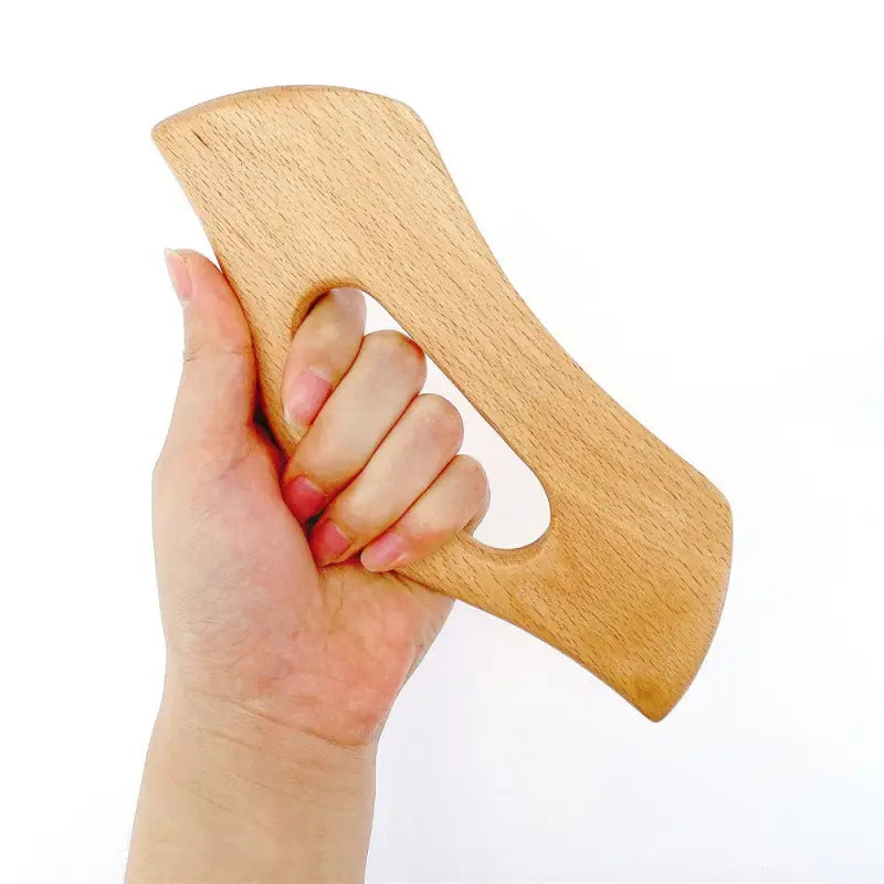 a hand holding a wooden knife blade
