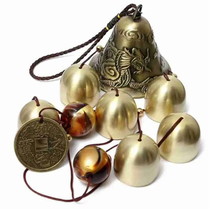 a brass bell with bells and a coin