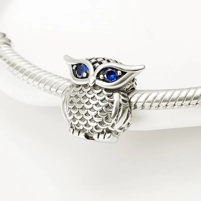 a silver bracelet with an owl charm