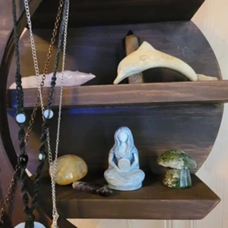 a wooden shelf with a necklace and a necklace holder