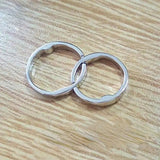 two silver rings on a wooden table