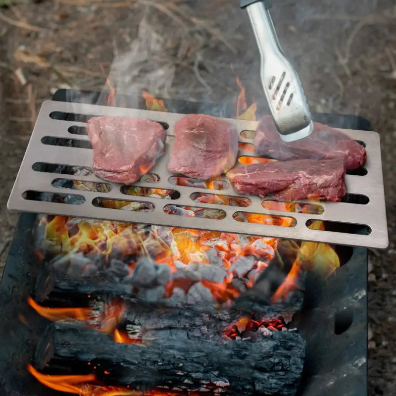 a steak is cooking on a grill with tongs