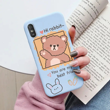 a woman holding a phone case with a bear on it