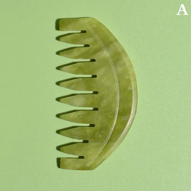 there is a green comb with a long handle on a green surface