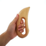 a hand holding a wooden toy
