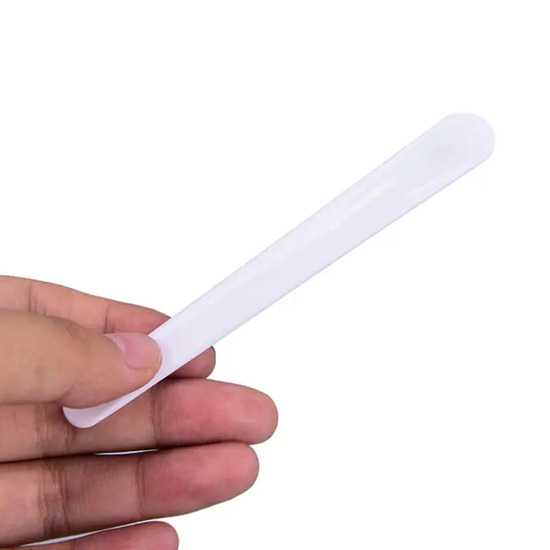 a hand holding a white plastic tooth