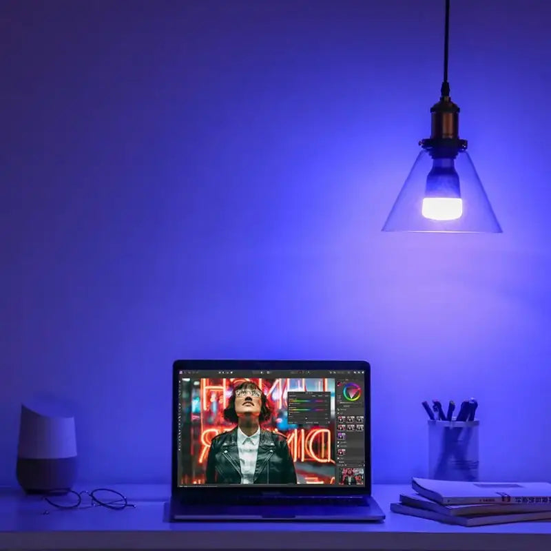 a laptop computer sitting on a desk with a light on it