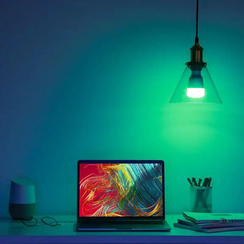 a laptop on a desk with a light on it