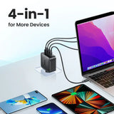 A laptop, phone and other devices on a table