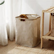 a white laundry bag next to a wooden chair