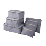 a set of three grey bags with gold lettering