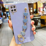 Lavender smartphone case with a decorative heart-shaped charm bracelet attached.