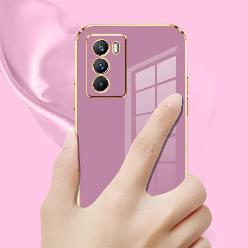 Lavender smartphone with gold trim and triple rear cameras held by a hand.