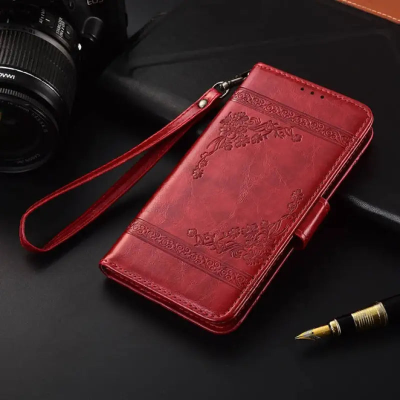 a red leather case with a camera and a pen