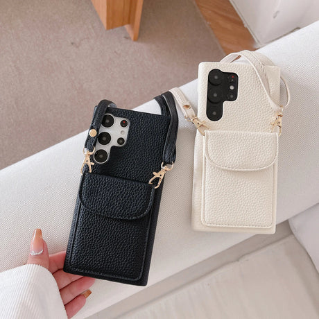 Leather phone cases with attached wallet pouches and straps in black and white colors.