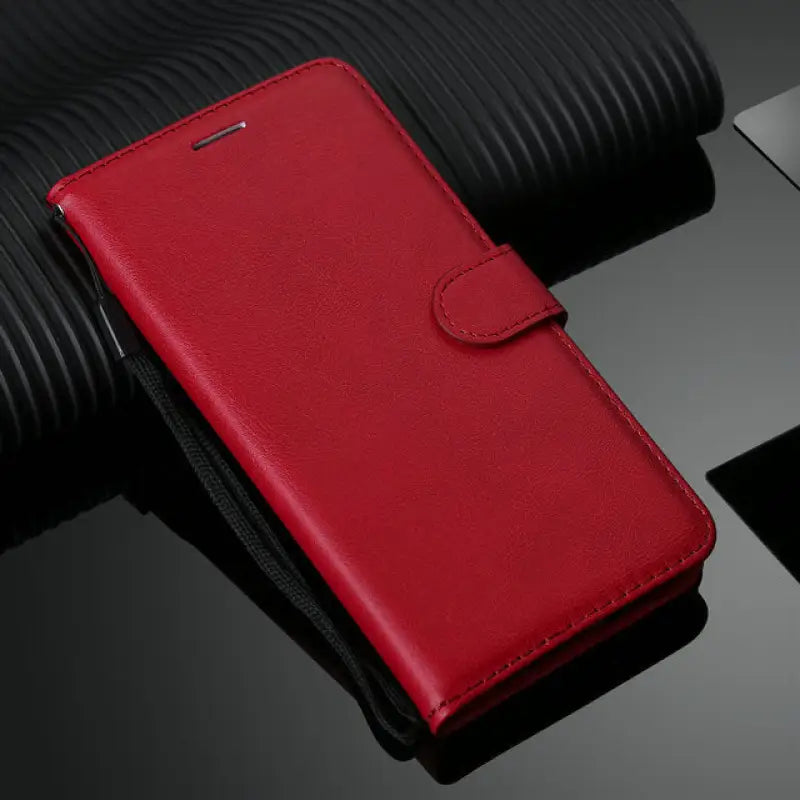 the red leather wallet case is shown on a black surface