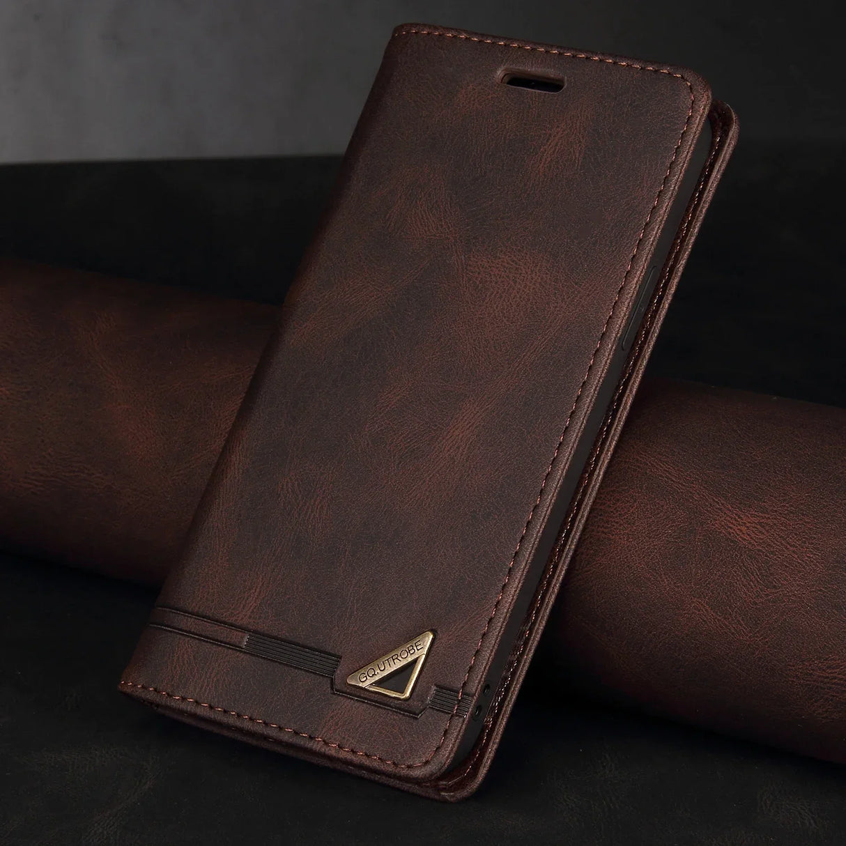 Leather wallet-style phone case with a metallic triangular emblem.