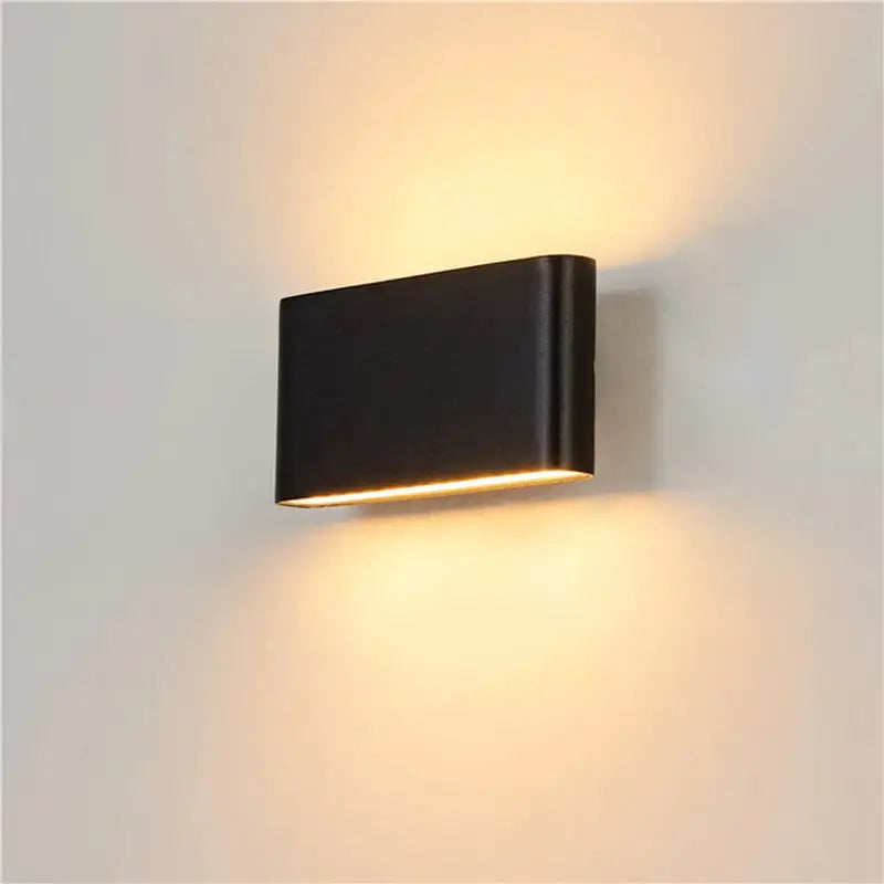 a black wall light with a white light