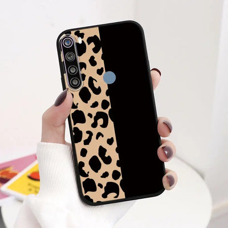 a woman holding a phone case with a leopard print