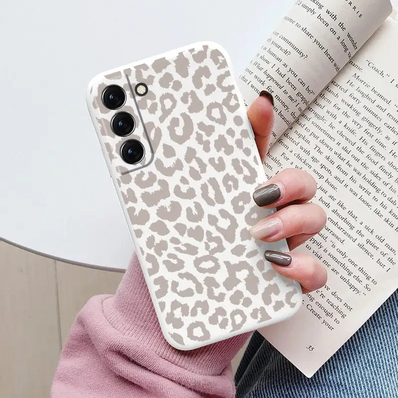 a woman holding a book and a phone case