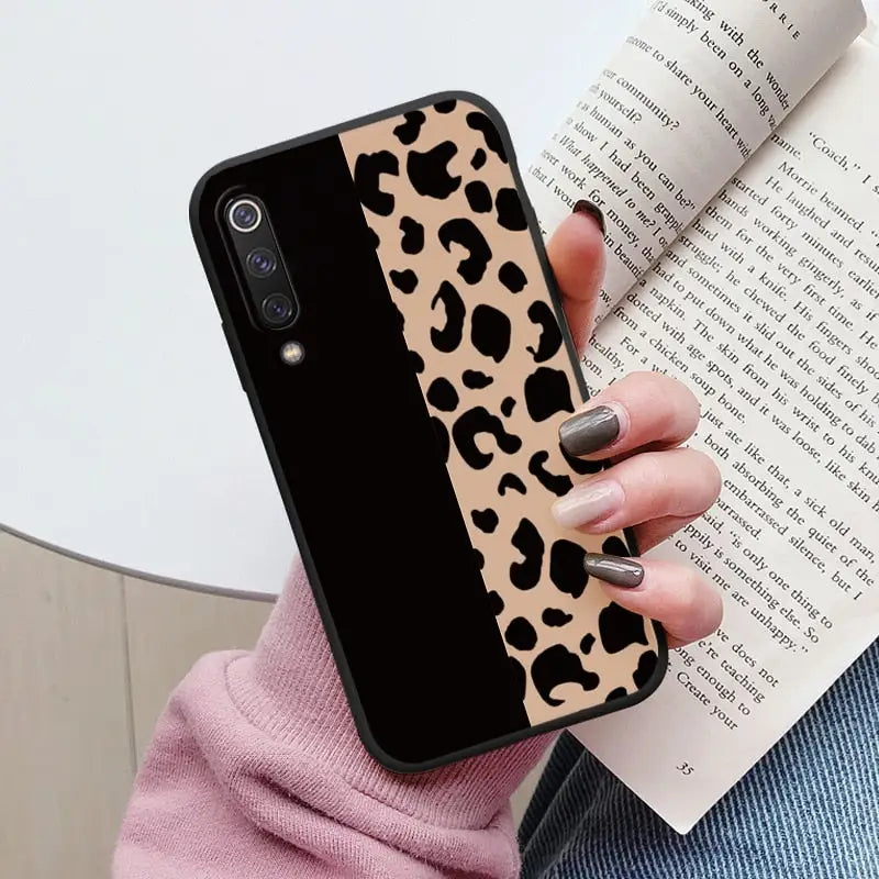 a woman holding a book and a phone case