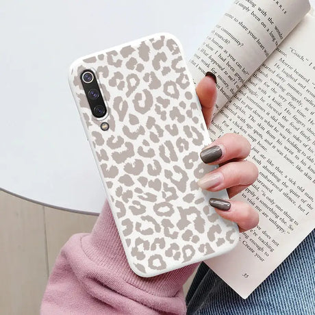 a woman holding a book and a phone case