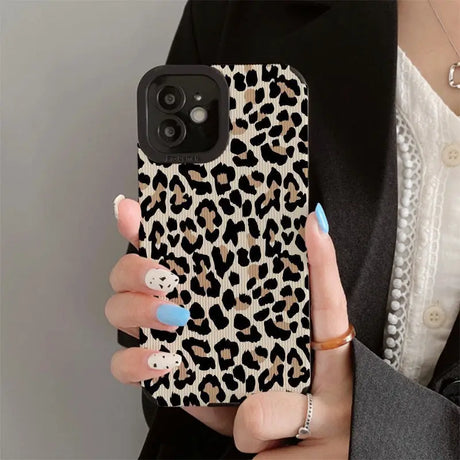 a woman holding a phone case with a leopard print