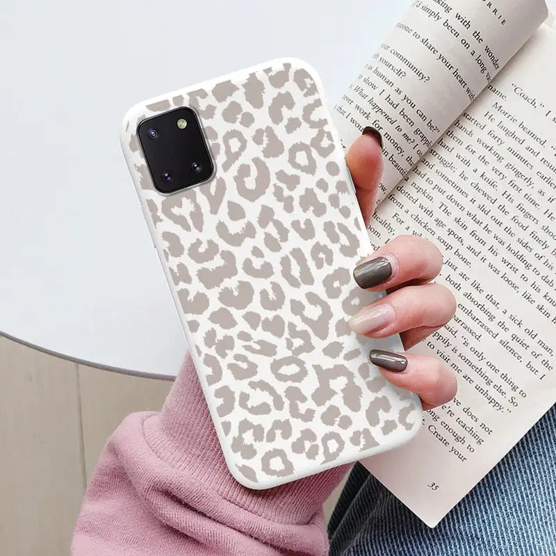 a woman holding a book and a phone case