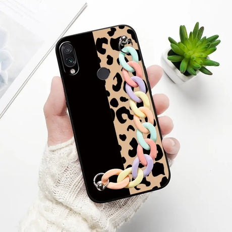 a woman holding a phone case with a leopard print