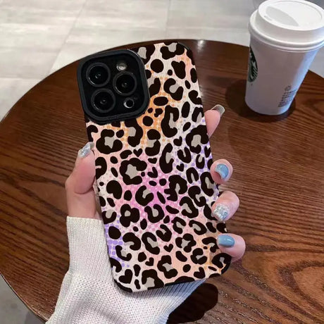 a woman holding a phone case with a leopard print