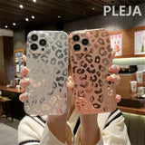 a woman holding up two iphone cases with leopard print