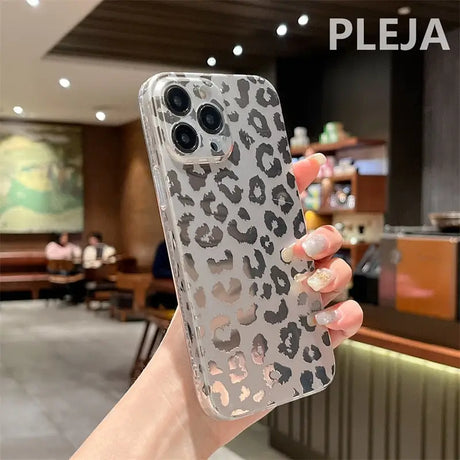 a woman holding up a phone case with a leopard print