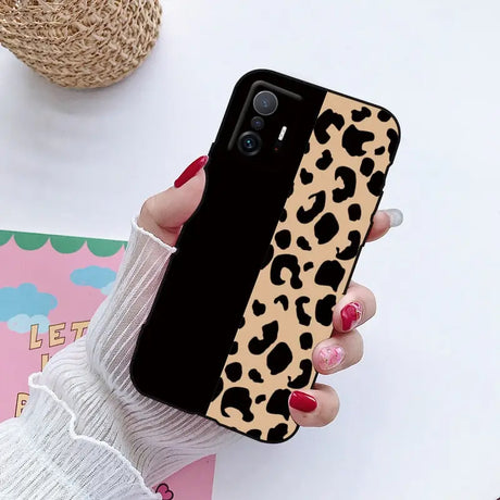 a woman holding a phone case with a leopard print