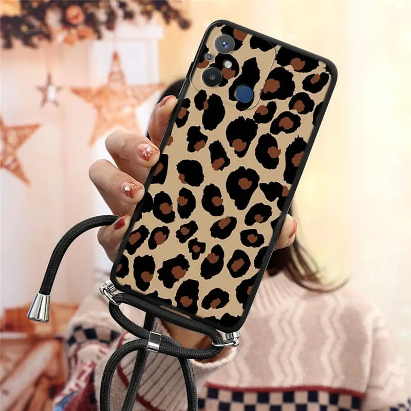 a woman holding a phone case with a leopard print