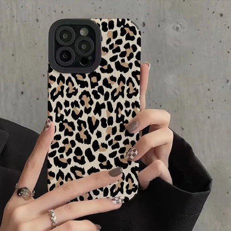 a woman holding a phone case with a leopard print