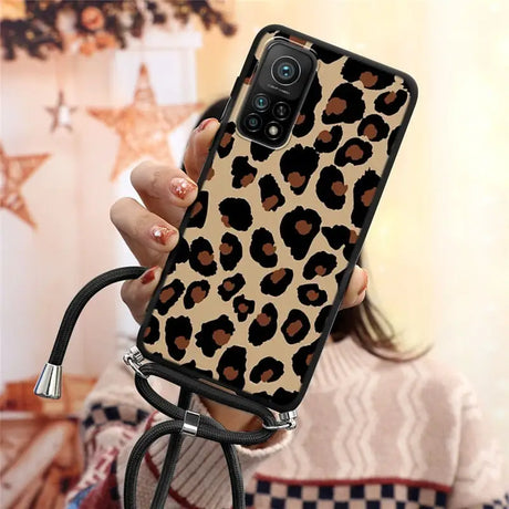 a woman holding a phone case with a leopard print