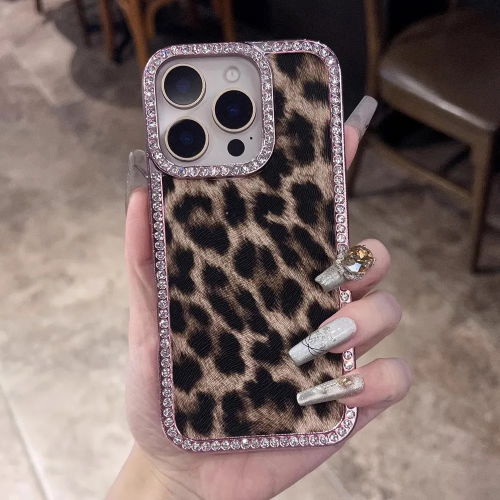 Leopard print phone case with a jeweled camera bezel and rhinestone border.