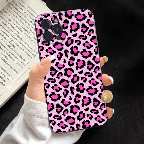 a woman holding a pink leopard print phone case