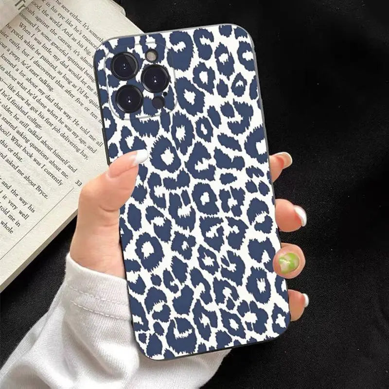 a woman holding a phone case with a blue and white leopard print