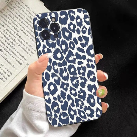 a woman holding a phone case with a blue and white leopard print