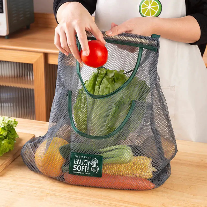 a woman holding a mesh bag filled with vegetables