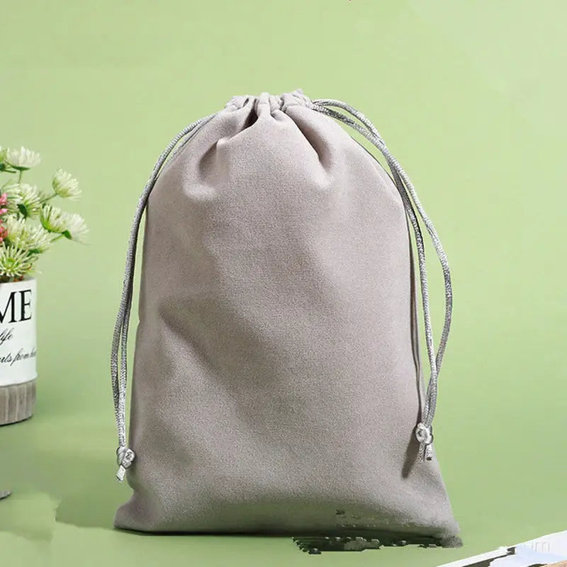 there is a bag with a drawstring on a table next to a plant