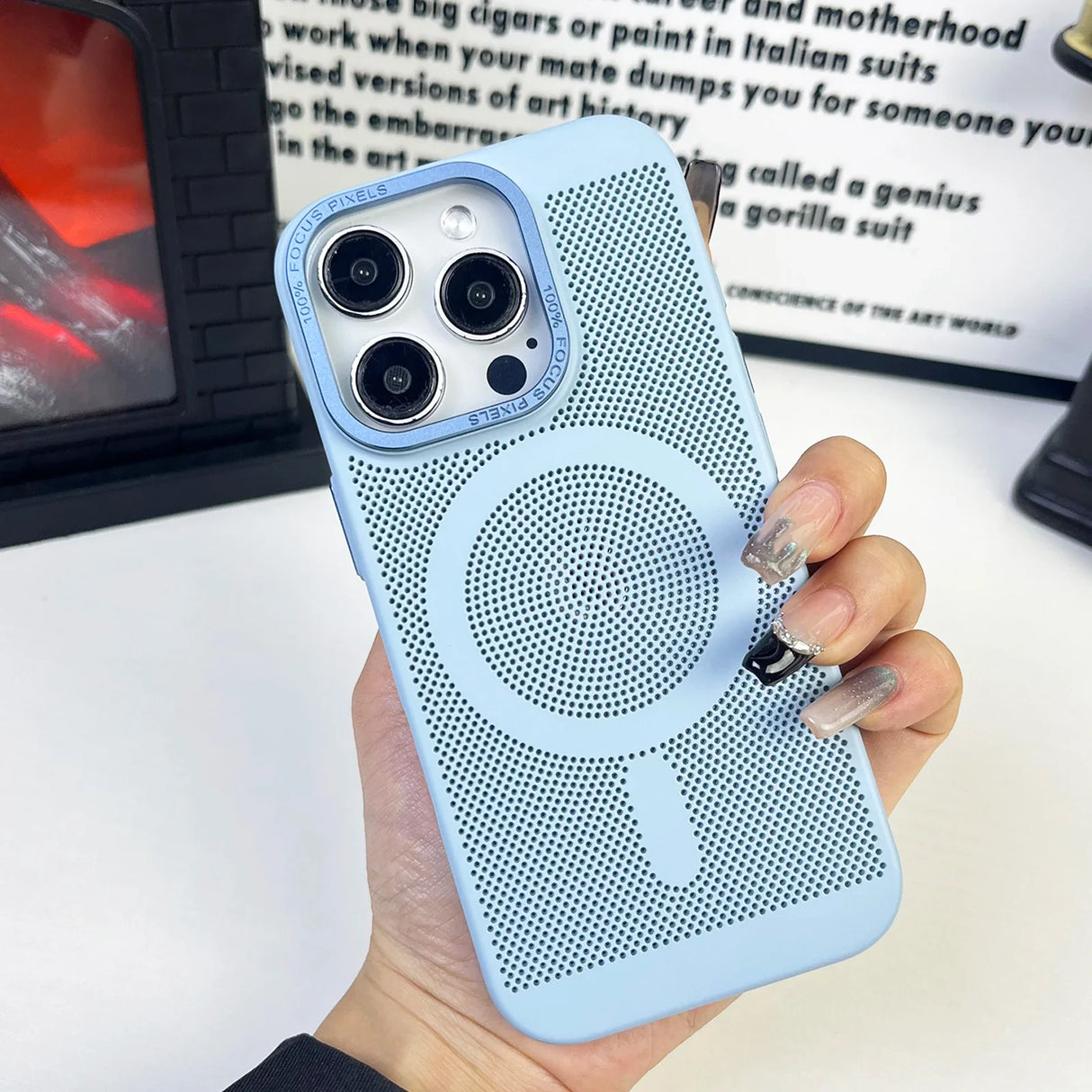 Light blue iPhone case with a circular MagSafe charging ring and triple camera cutout.