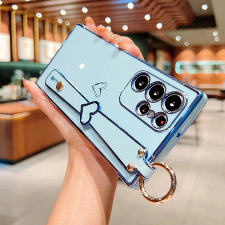 Light blue phone case with a heart-shaped hand strap and a circular ring holder.
