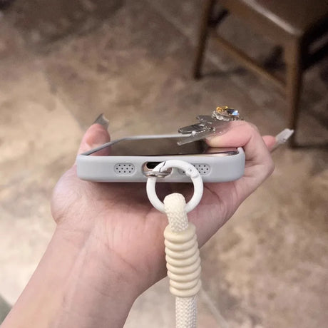 A light gray phone case with a white lanyard attached.