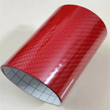 a roll of red plastic tape on a white surface