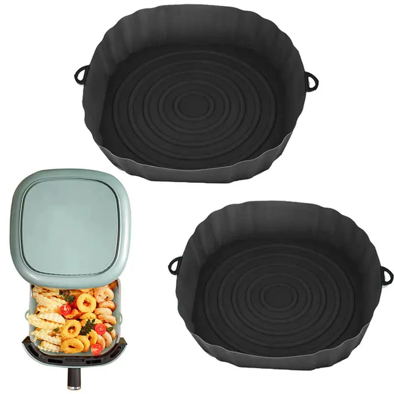 two black pans with food inside of them and a container with food inside