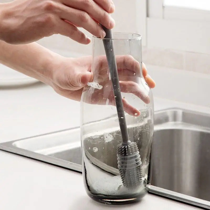 a person is cleaning a glass with a brush